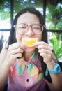 Portrait of happy asian woman in a cafe with mandlin orange against of a mouth like a smile,say cheese concept,happy with food Royalty Free Stock Photo