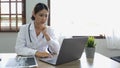 Portrait happy asian woman doctor, Telemedicine concept. Asian female doctor talking with patient using laptop online video Royalty Free Stock Photo