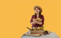 Portrait of a happy Asian woman farmer standing smiling and holding fresh cacao fruit on hands isolated on yellow background Royalty Free Stock Photo