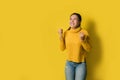 Portrait of a happy Asian woman screaming an excited and celebrating success isolated over yellow background. Succeed Royalty Free Stock Photo