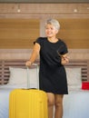 Portrait of happy and attractive 40s to 50s mature Asian woman with grey hair arriving in hotel room excited smiling  cheerful Royalty Free Stock Photo