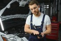 Portrait Of A Happy Auto Mechanic Cleaning Hands With Cloth Royalty Free Stock Photo