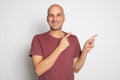 Portrait of a happy bald man in red t-shirt pointing fingers