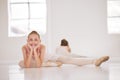 Portrait of happy ballet dancer on a break from training in a dance studio, smiling and stretching. Excited, flexible