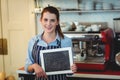 Portrait of happy barista holding blank chalkboard at cafe Royalty Free Stock Photo