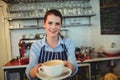 Portrait of happy barista offering coffee at cafe Royalty Free Stock Photo