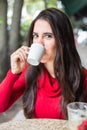 Portrait of happy beautiful brunette with mug in hand and drinking coffee