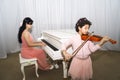 Portrait of happy beautiful dark skinned little girl using a violin while playing a melody