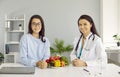 Professional dietitian or nutritionist giving consultation about healthy food to young woman Royalty Free Stock Photo