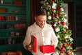 Portrait of happy beautiful emotional man opening Christmas gift box Royalty Free Stock Photo