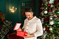 Portrait of happy beautiful emotional man opening Christmas gift box at his home Royalty Free Stock Photo