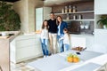 Happy beautiful family looking at the camera in the kitchen at home