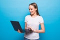 Portrait of a happy beautiful girl pointing finger at blank screen laptop isolated over blue background Royalty Free Stock Photo