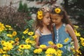 Portrait of happy beautiful girls in flowerbed Royalty Free Stock Photo