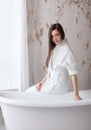 Portrait of happy beautiful woman with brown long hair in bathroom