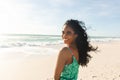 Portrait of happy beautiful young biracial woman looking over shoulder at beach enjoying sunny day Royalty Free Stock Photo