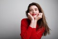 Portrait of happy and beautiful young caucasian woman wearing red top and red lipstick. Posing over white background. Royalty Free Stock Photo