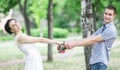 Portrait of happy beautiful young couple female bride with small wedding flowers roses bouquet and male bridegroom holding hands, Royalty Free Stock Photo