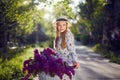 Portrait of a happy beautiful young girl with vintage bicycle and flowers on city background in the sunlight outdoor Royalty Free Stock Photo