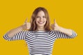 Portrait of happy beautiful young woman smiling and giving thumbs up with both hands Royalty Free Stock Photo