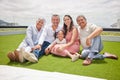 Portrait of happy big family with girl, love and a smile while sitting on backyard, lawn or grass. Grandfather Royalty Free Stock Photo