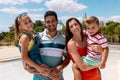 Portrait of happy biracial family embracing by the swimming pool Royalty Free Stock Photo