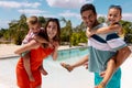 Portrait of happy biracial family smiling by the swimming pool Royalty Free Stock Photo