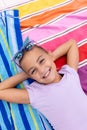 Portrait of happy biracial girl smiling and lying on towel by the swimming pool Royalty Free Stock Photo