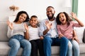 Portrait of a happy black family waving hands at camera Royalty Free Stock Photo