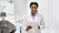 Portrait of happy black female dentist in white coat with digital tablet Royalty Free Stock Photo