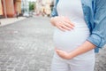 Portrait of a happy black hair and proud pregnant woman in a city in the background. Close-up image of female model