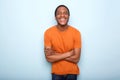 Happy black man smiling with arms crossed against blue wall Royalty Free Stock Photo