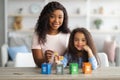 Portrait of happy black mom and her little daughter playing wooden sorting garbage game at home Royalty Free Stock Photo