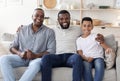 Portrait of happy black multigenerational men family posing on couch at home Royalty Free Stock Photo