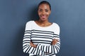 Portrait, happy and black woman with arms crossed, fashion and model on a blue studio background. Face, African person Royalty Free Stock Photo