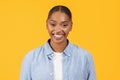 portrait of happy black woman in denim attire, yellow background Royalty Free Stock Photo