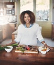 Portrait of happy black woman preparing healthy food in a kitchen at home. Young African American using fresh vegetables Royalty Free Stock Photo