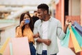 Portrait of happy black woman showing credit card to man Royalty Free Stock Photo