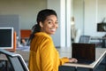 Portrait of happy black woman sitting at desk showing laptop with blank black screen, office interior, mockup Royalty Free Stock Photo