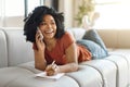 Happy Black Woman Talking On Cellphone While Lying On Couch At Home Royalty Free Stock Photo
