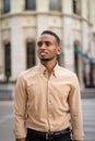 Portrait of happy black young African businessman thinking outdoors in city Royalty Free Stock Photo