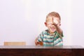 Portrait of happy blond boy child kid pointing at you at the table Royalty Free Stock Photo