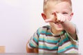 Portrait of happy blond boy child kid pointing at you at the table Royalty Free Stock Photo