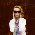 Portrait of happy blond girl posing over shabby rusty wall