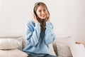 Portrait of happy blond girl 20s wearing headphones smiling and listening to music at home Royalty Free Stock Photo