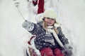 Portrait of happy blondy child in winter park playing in snow