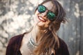 Portrait of happy boho girl in cool outfit and sunglasses smiling in sunny street. Stylish hipster carefree girl posing on Royalty Free Stock Photo