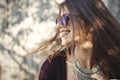 Portrait of happy boho girl in cool outfit and sunglasses smiling in sunny street. Stylish hipster carefree girl posing on Royalty Free Stock Photo