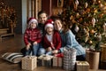 Portrait of happy bonding family sitting near decorated tree. Royalty Free Stock Photo