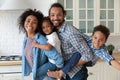 Portrait of happy African parents holding on backs smiling kids. Royalty Free Stock Photo